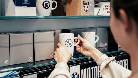 employee puts cup on shelf in bmw welt store